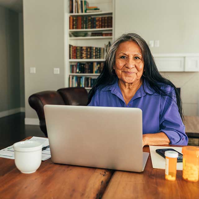 Mature woman seated with laptop computer